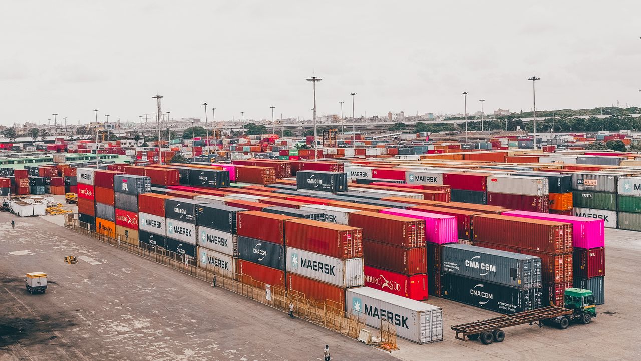 Colorful shipping containers stacked at a bustling port showcasing global trade.